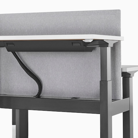 A close-up view of a Renew Link standing desk system's cable management.