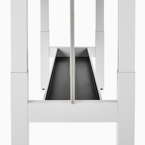 A close-up view of a Renew Link standing desk system's basic cable trough.