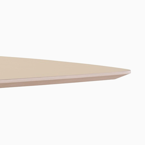 A close-up view of a Renew Link standing desk system's light wood work surface's thin edge.