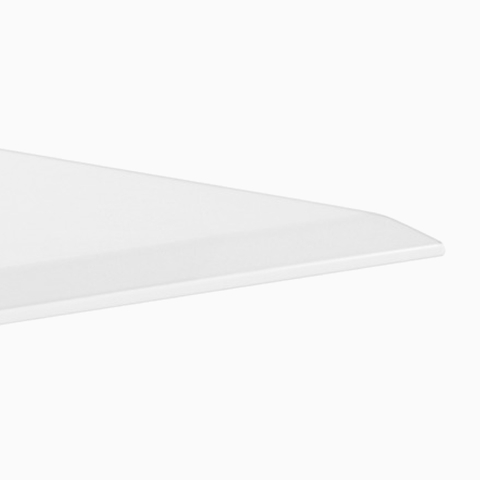 A close-up view of a Renew Link standing desk system's white work surface's eased edge.