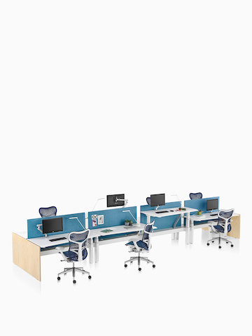 A Renew Link standing desk system with blue Mirra 2 office chairs and blue fabric divider panels. Two of the eight desks are raised to standing height.
