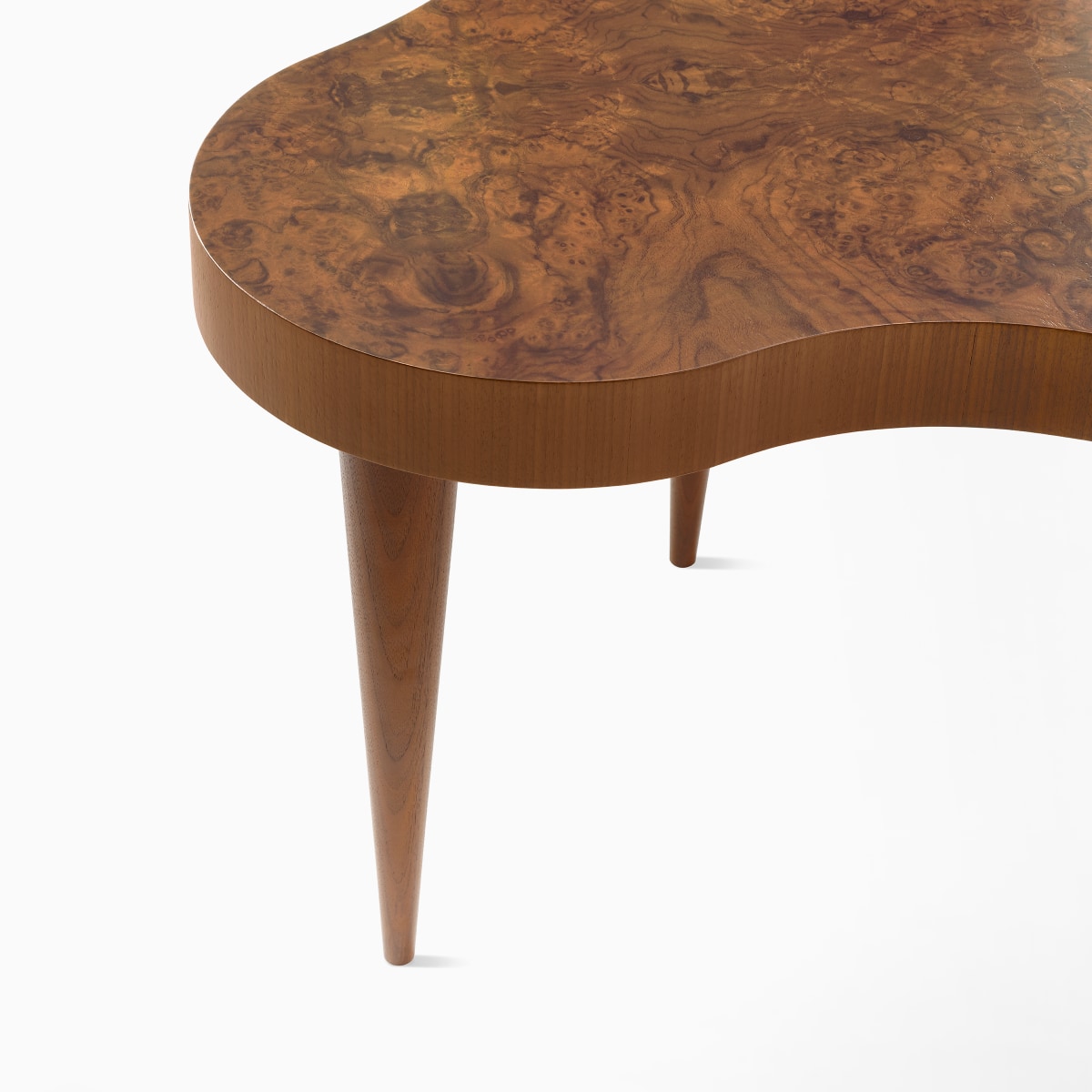 Close-up view of the tapered leg on a Rohde side table in walnut burl. 