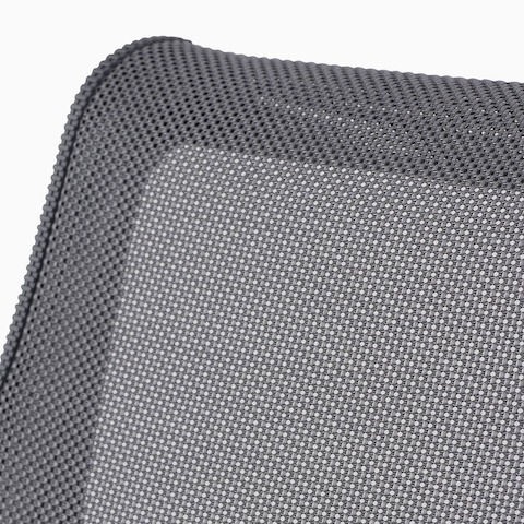 A close-up view of the suspension material on a gray Setu chair.