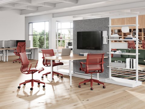 A workplace neighborhood that features red Setu Chairs and Stools, a variety of flexible work points, a focused space, and a lounge area.