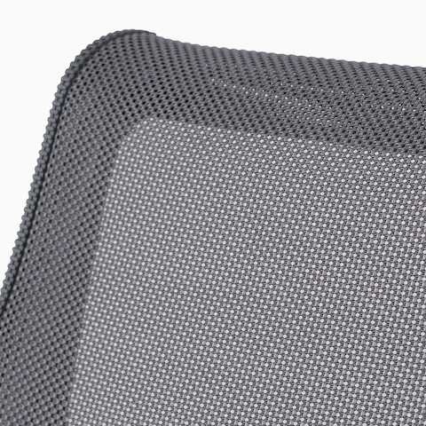 A close-up view of the suspension material on a gray Setu chair.
