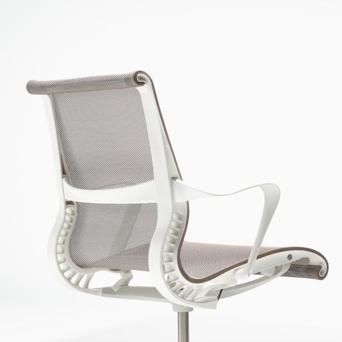 Rear-angle view of a Setu chair with fixed arms, a studio white frame, silver alloy base, and cocoa brown suspension.