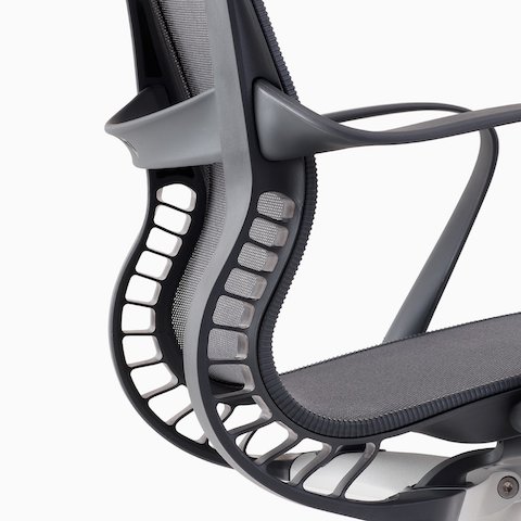 A close-up view of the Kinematic Spine on a gray Setu chair.