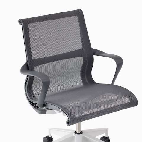 A close-up view of a Setu chair with arms in gray.