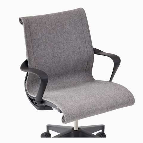 A close-up view of an upholstered Setu chair with arms in gray.