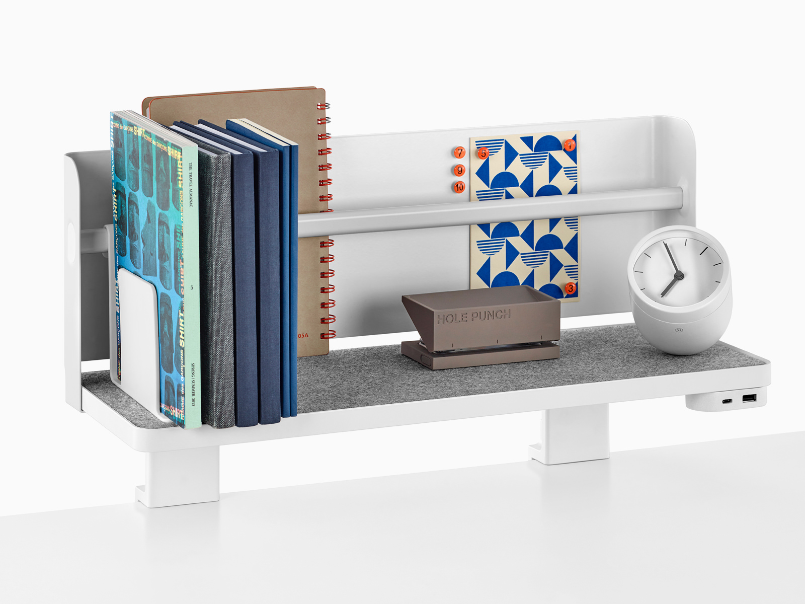 A Ubi Attached Shelf with a backdrop supports books, a hole punch, a desk clock, and a USB power module.