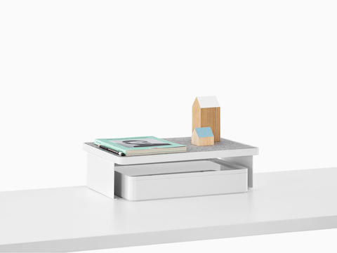 A Ubi Freestanding Shelf with personal items on top and a storage box below.
