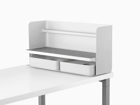 Een kleine witte Ubi-desktoporganizer met een grijze antislipplank en twee opbergdozen.