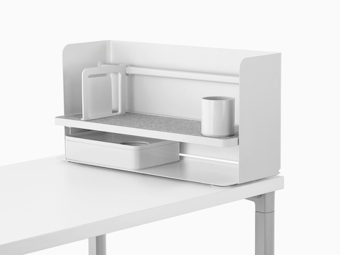 Een kleine witte Ubi-desktoporganizer met een boekensteun, potloodbeker, grijze antislipplank en opbergdoos.
