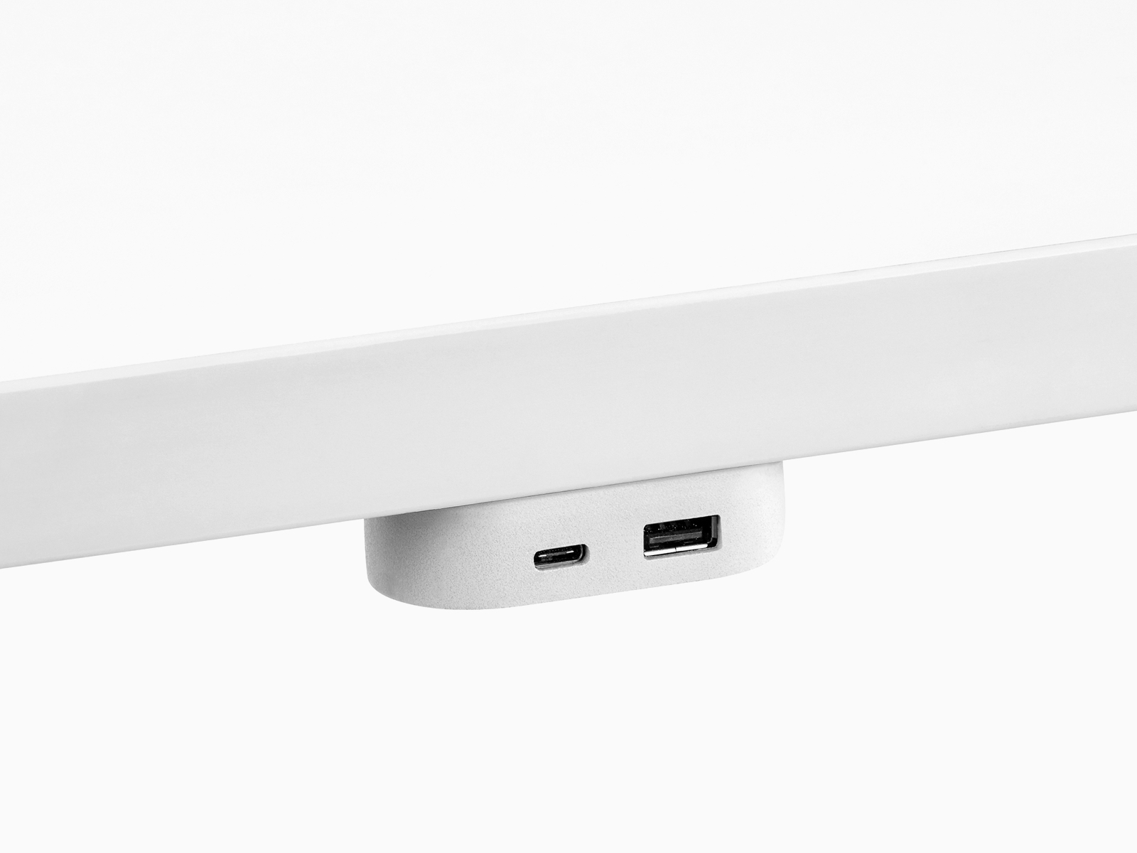 A Ubi USB Power Module attached to the underside of a work surface and containing two USB ports of different sizes.