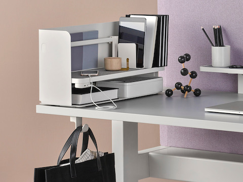 Partial view of a work surface with a Ubi Organizer on top and Ubi Bag Hook below.