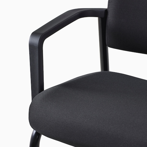 A close-up view of a black Verus Plus Chair upholstered seat and arm.