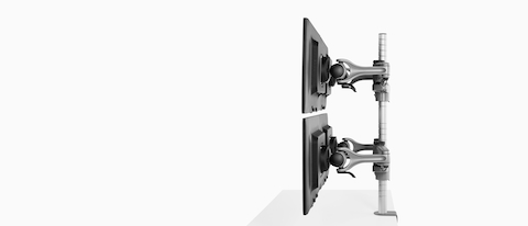 Profile view of four monitors attached to a single heavy-duty Wishbone Plus monitor arm post.