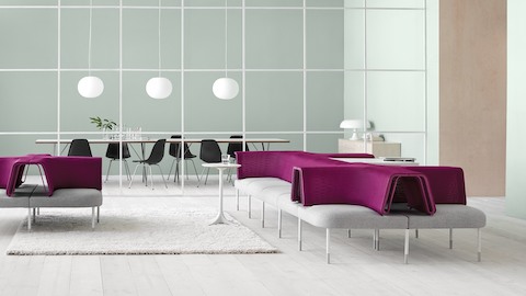 Gray and magenta Public Office Landscape seating adjacent to a glass-walled meeting room containing Eames Molded Plastic Chairs.