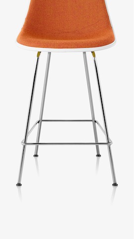 Partial view of an Eames Molded Plastic Stool with orange upholstery. Select to see stools available from the Herman Miller Store. 