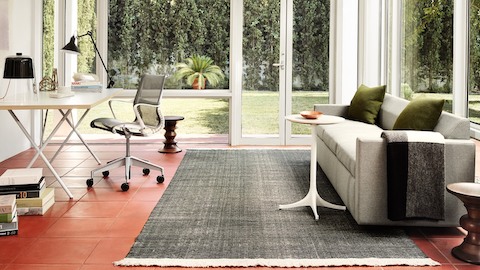 A home office with a Setu Chair and Nelson X-Leg Table. Select to see office chairs available from the Herman Miller Store.