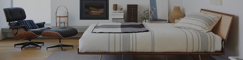 A bedroom featuring a black leather Eames Lounge Chair and Ottoman and a Nelson Miniature Chest.