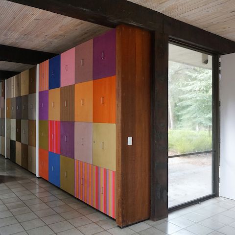 A grid of colorful and patterned squares show the storage cabinets that line the hallway walls.