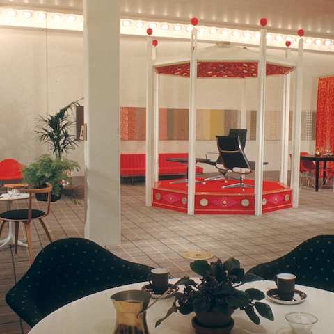 A color photo of the 1958 Herman Miller San Francisco showroom, featuring two black chairs from Eames Aluminum Group and two upholstered Eames Shell chairs.