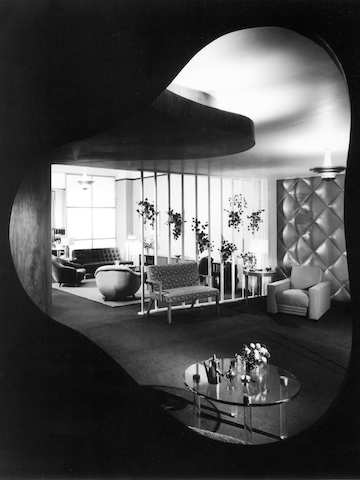 A black and white archival photo of Gilbert Rohde’s 1939 Herman Miller Chicago showroom, as seen through a biomorphic-shaped opening.