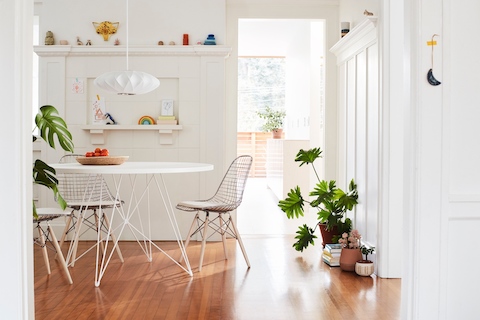 Eames Wire Chairs with dowel base surround a Magis Tavolo table beneath a Nelson Bubble Pendant